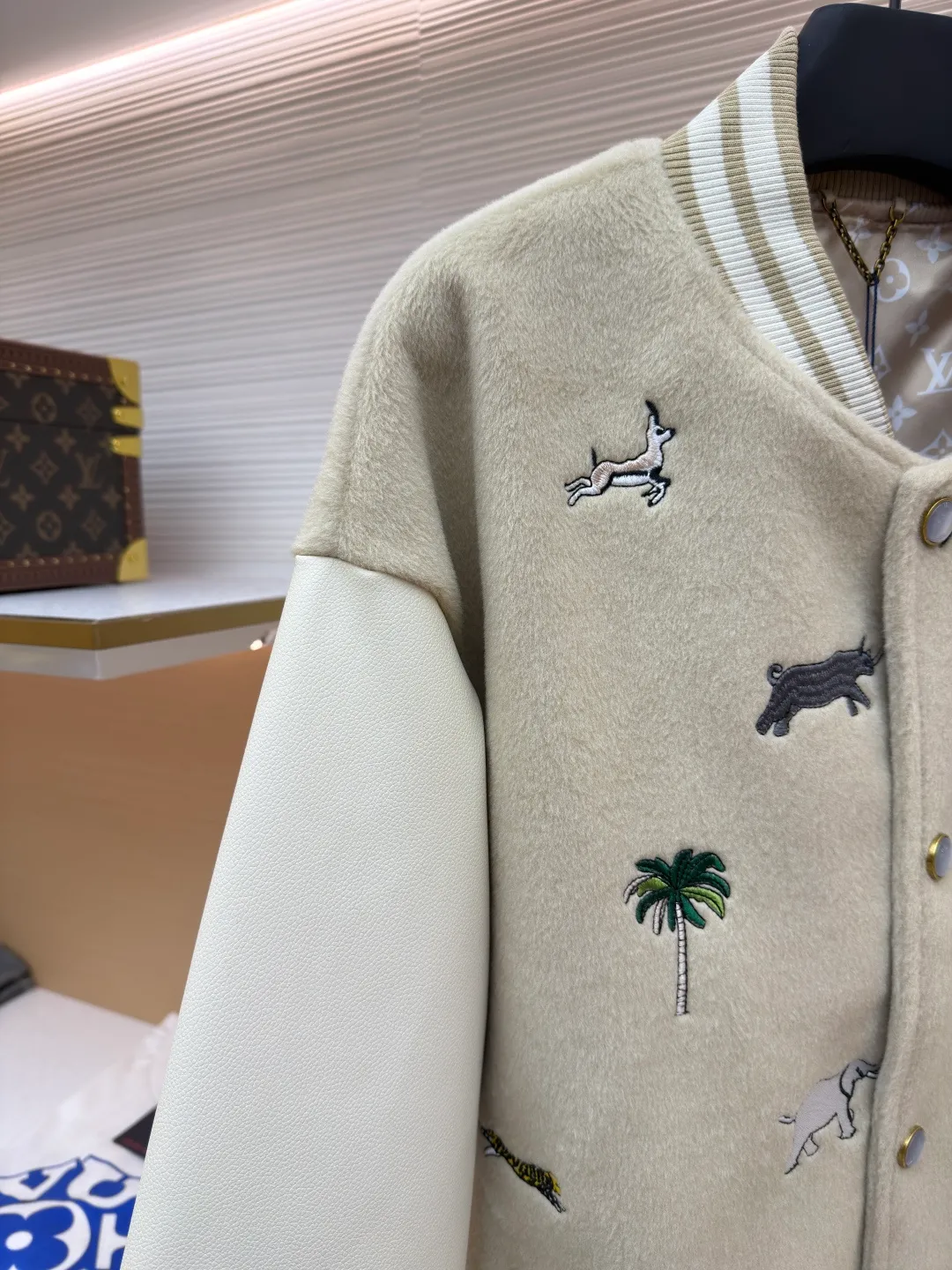LOUIS VUITTON animal embroidered baseball uniform ●Original version: 48000 purchased and developed ●Item number: 1682284-B90 ●Fabric: cotton fabric ●Technology: embroidery production ●Color: apricot ●Version: fitted version ●Weight: about 1070 grams ●Size: 46-48-50-52 ●Description: The main body of this Louis Vuitton embroidered baseball jacket is made of high-quality wool blended fabric, which is crisp and soft. The sleeves are made of eco-friendly artificial leather with a matte texture, which contrasts with the body in terms of material and touch. The animal, palm tree and other patterns on the body of the clothing are all completed by hand-stitched embroidery technology, using multi-color embroidery threads to embroider in layers. The patterns are three-dimensional and vivid, and the stitching in the details is fine and even. The letter logo uses flat embroidery technology, and the font outline is clear and regular. The ribbed collar, cuffs and hem of the jacket are made of high-elastic knitted fabric, which will not loosen easily after being worn for a long time. The metal snaps on the placket are custom-made hardware with a thick texture and anti-oxidation. The overall tailoring is a loose oversize version, and the splicing uses hemming stitching technology, and the lines are smooth and smooth. Every craft detail is in line with the brand's luxury product production standards, creating a ready-to-wear garment that has both a sense of design and practical wearability. The overall wiring is straight and delicate, the fabric is comfortable and soft, and the color is consistent without color difference. It can be matched with the same style to create a fashionable look and control various occasions. Customized accessories, complete with three standards, same style for men and women!